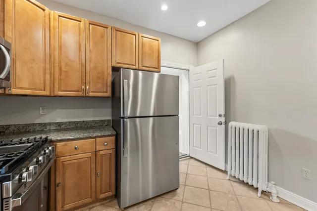 a kitchen with a refrigerator a stove top oven and cabinets