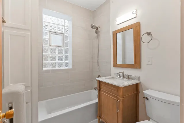 a bathroom with a granite countertop sink toilet a mirror and shower