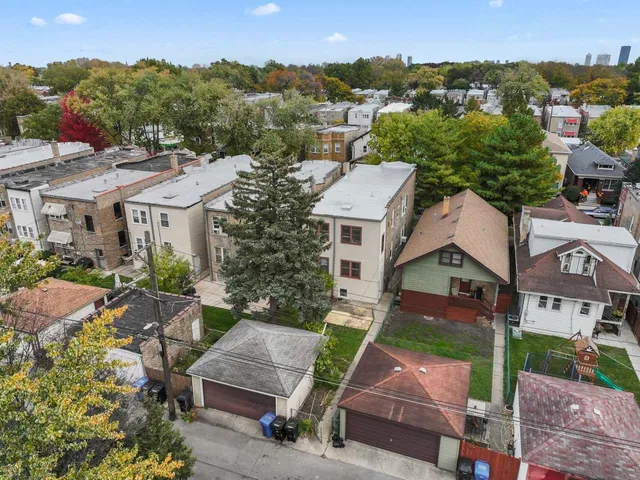 an aerial view of multiple houses with a yard