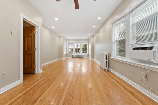 a view of a big room with wooden floor and windows