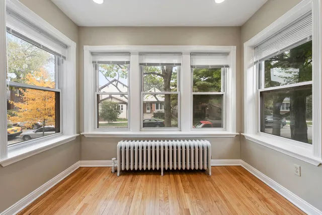 a view of a room that has a large window and wooden floor
