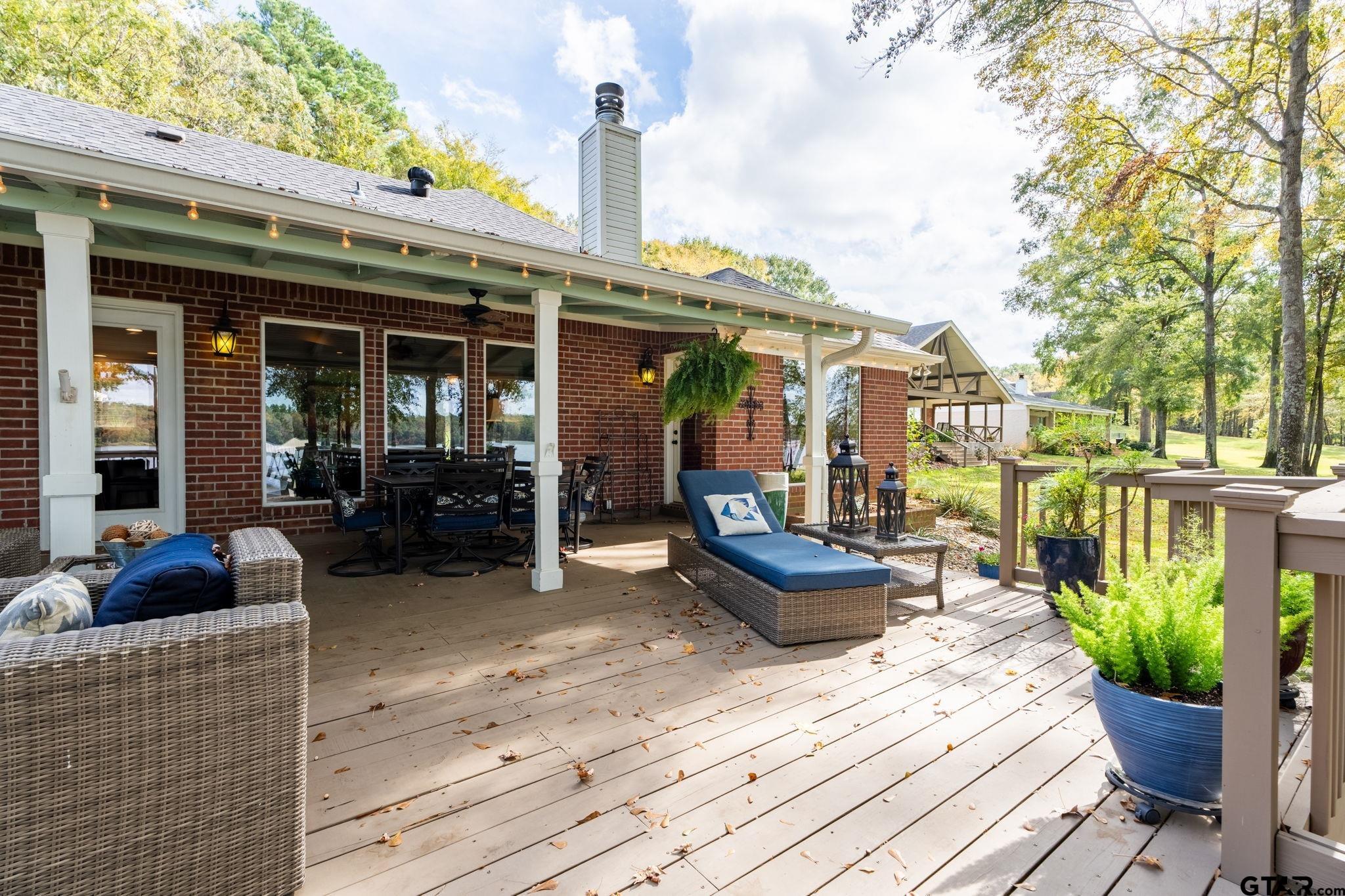 14312 East Ridge Road Arp, TX 75750 - Photo 27 of 44 a view of a patio with couches chairs potted plants and wooden floor
