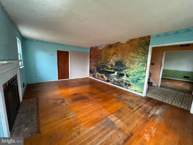 a view of an empty room with a fireplace and a window