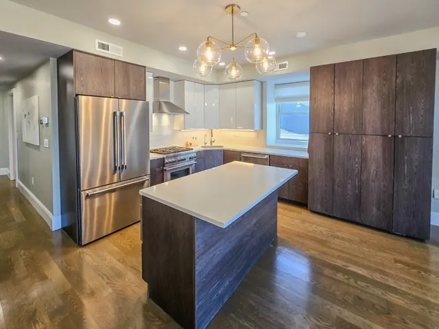 a kitchen with refrigerator cabinets and wooden floor
