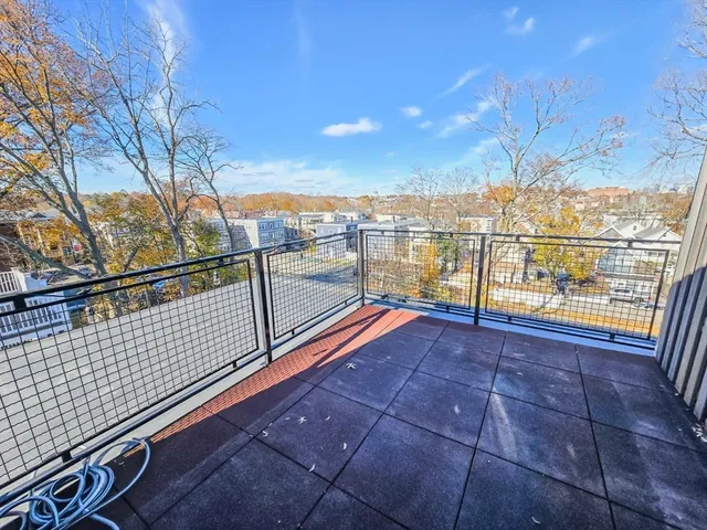 a roof deck with couches and wooden floor