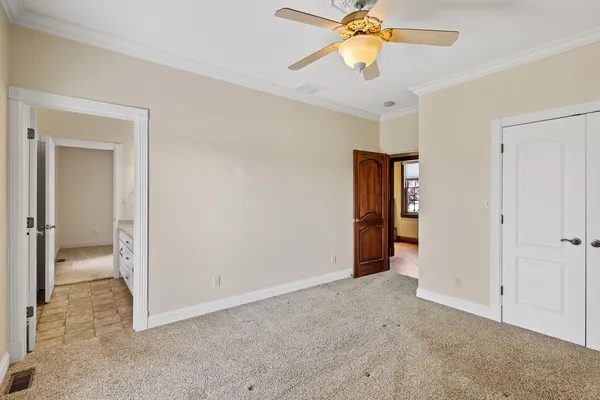 a view of an empty room and chandelier fan