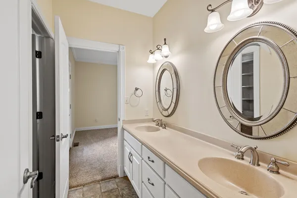 a bathroom with a granite countertop double vanity sink and a mirror
