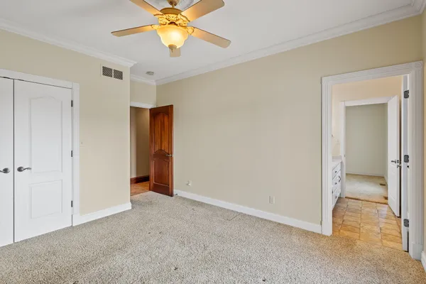 a view of an empty room and chandelier fan