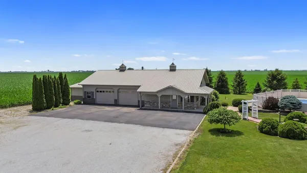 a view of a house with a big yard plants and large tree