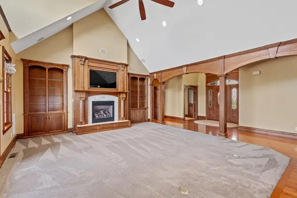 a view of an empty room with a fireplace and a window