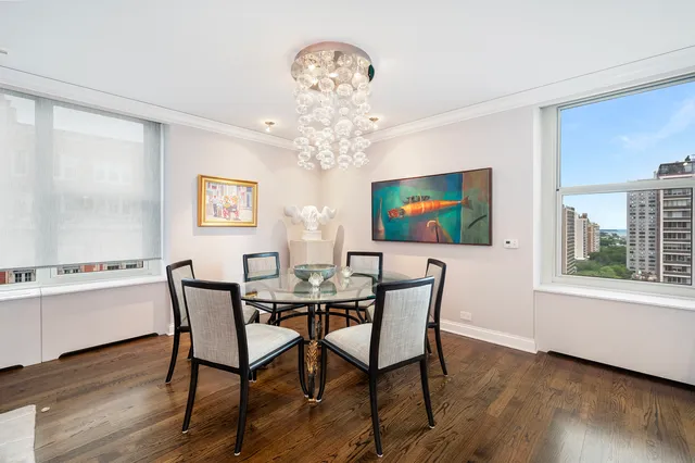 a view of a dining room with furniture a chandelier and wooden floor