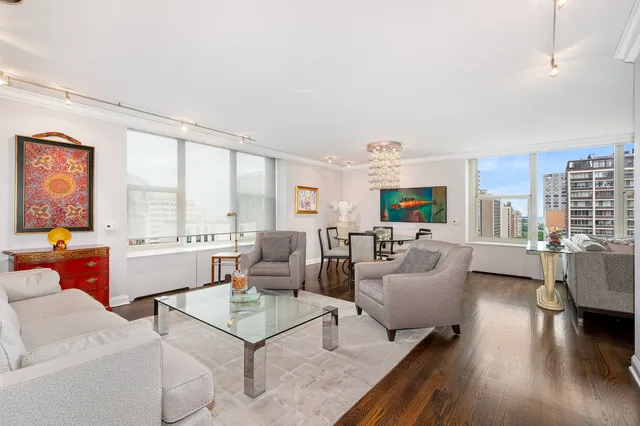 a living room with furniture large window and wooden floor