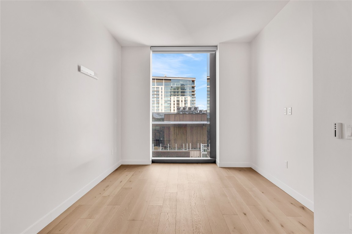 44 East Avenue, Unit 3107 Austin, TX 78701 - Photo 19 of 40 an empty room with wooden floor and windows