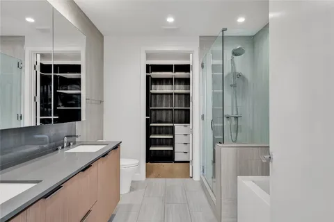 a bathroom with a granite countertop tub sink and mirror