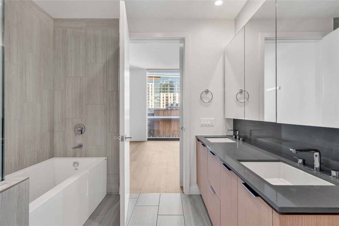 44 East Avenue, Unit 3107 Austin, TX 78701 - Photo 25 of 40 a bathroom with a granite countertop tub sink and mirror