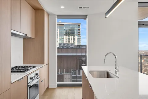 a kitchen with stainless steel appliances a stove and white cabinets