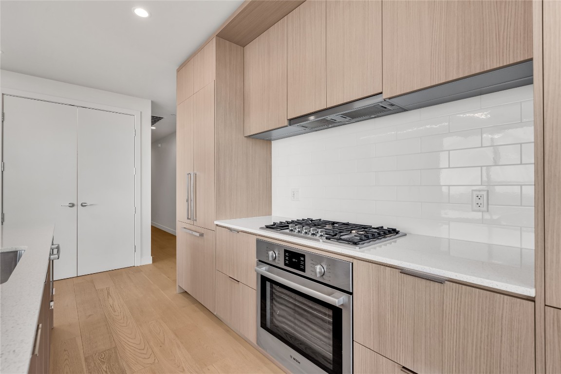 44 East Avenue, Unit 3107 Austin, TX 78701 - Photo 6 of 40 a kitchen with stainless steel appliances a stove and white cabinets
