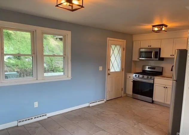 a kitchen with stainless steel appliances a stove microwave and refrigerator