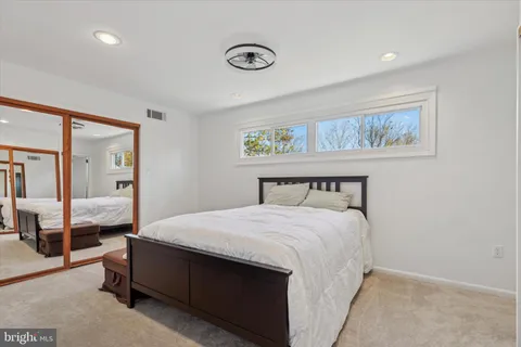 a bedroom with a bed and a mirror