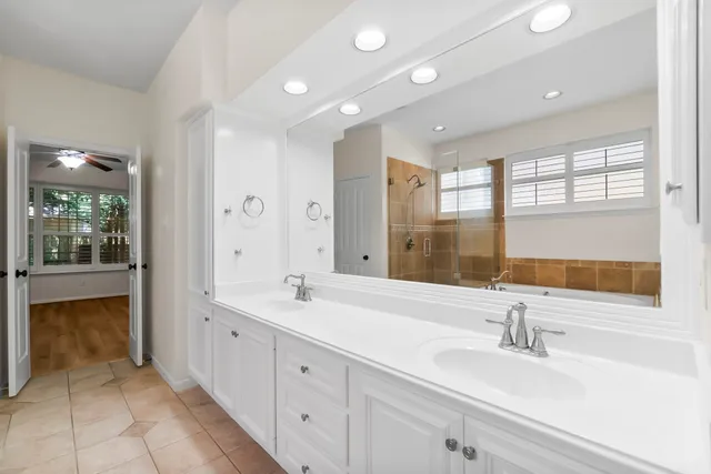 a spacious bathroom with a double vanity sink and mirror
