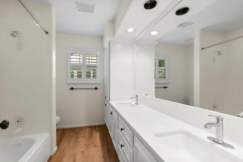a spacious bathroom with a tub a sink and a large mirror