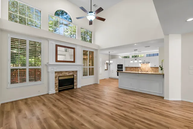 a view of an empty room with a window and kitchen view