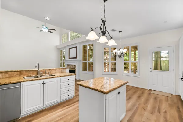 a view of a kitchen island a sink dishwasher a fireplace with wooden floor