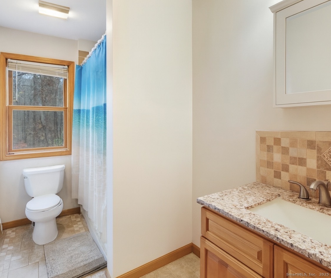 63 Buck Hill Road Canterbury, CT 06331 - Photo 12 of 25 a bathroom with a granite countertop sink a toilet and a mirror