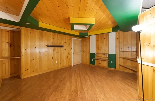 a view of a room with wooden floor a cabinet and windows