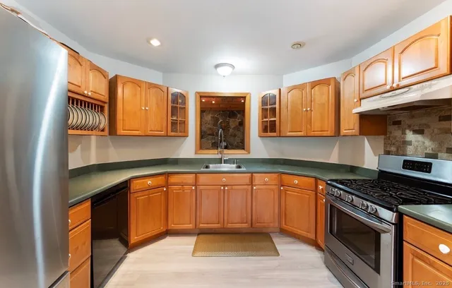 a kitchen with stainless steel appliances granite countertop a stove a sink and a microwave