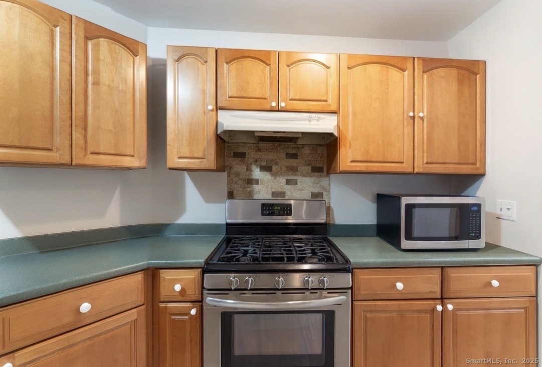 63 Buck Hill Road Canterbury, CT 06331 - Photo 5 of 25 a kitchen with granite countertop a stove a sink and a microwave