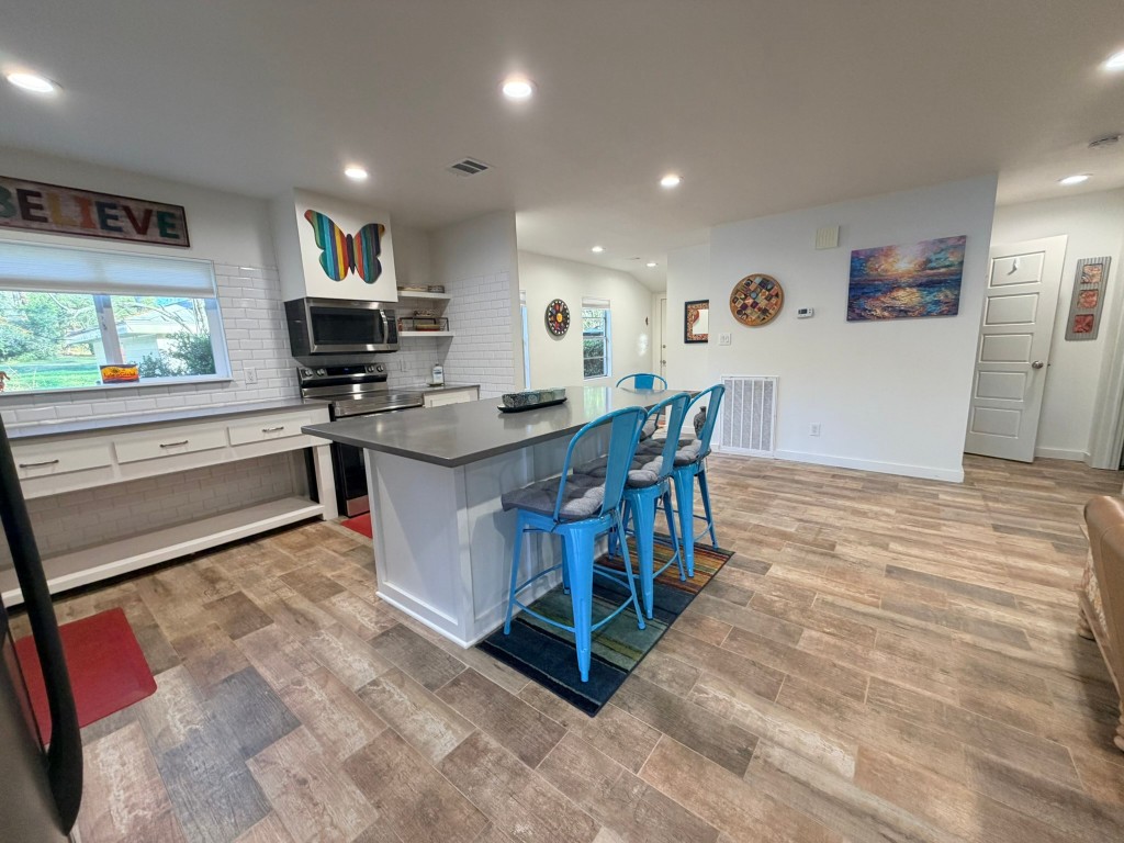251 County Road Goodrich, TX 77335 - Photo 11 of 50 a kitchen with stainless steel appliances kitchen island granite countertop a sink a stove a dining table and chairs