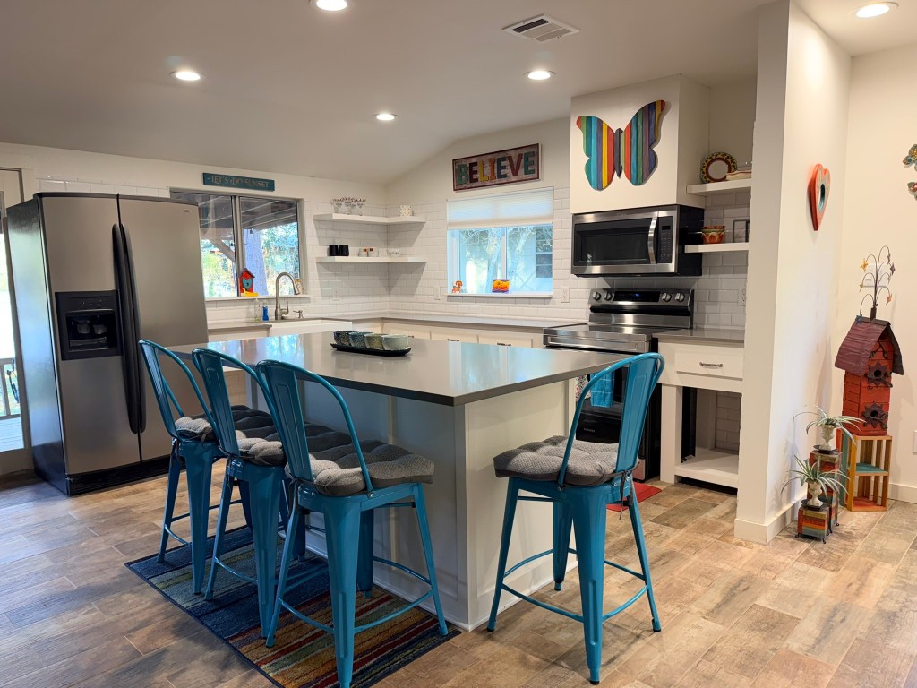 251 County Road Goodrich, TX 77335 - Photo 10 of 50 a kitchen with stainless steel appliances kitchen island granite countertop a table chairs refrigerator and microwave
