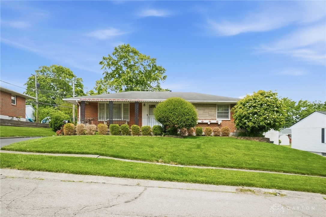 877 Woodhill Road Riverside, OH 45431 - Photo 3 of 42 Charming single-story residence with a meticulously maintained front lawn and classic brick facade.