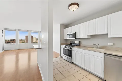 a kitchen with granite countertop a sink cabinets and stainless steel appliances