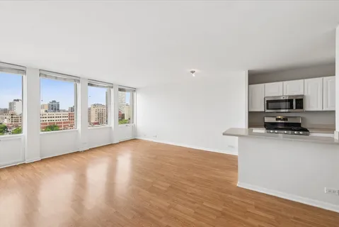 a view of a kitchen with microwave and wooden floor
