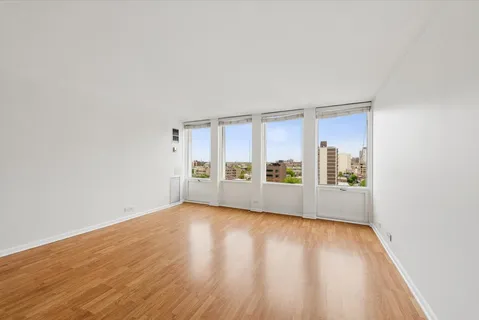 a view of a room with wooden floor and a window