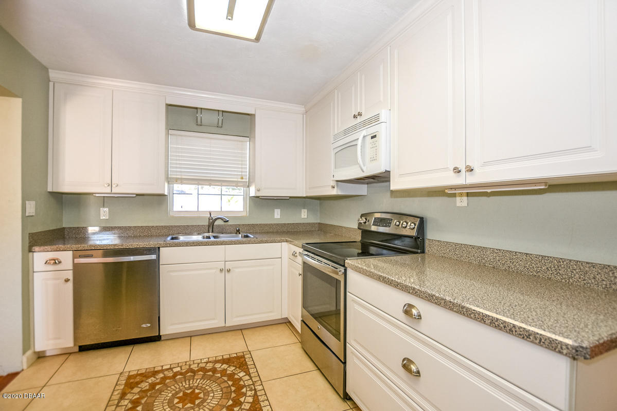 1509 Ridge Avenue Holly Hill, FL 32117 - Photo 13 of 40 a kitchen with stainless steel appliances granite countertop a sink and a stove