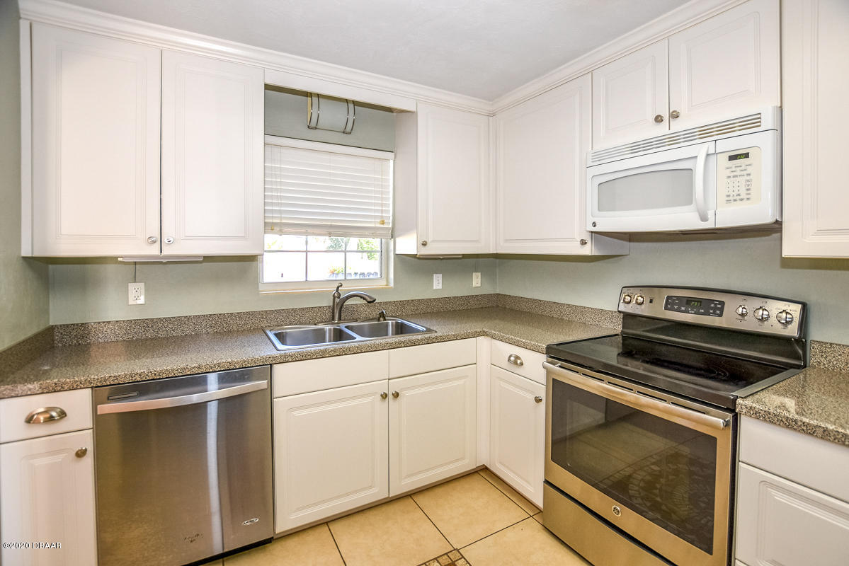 1509 Ridge Avenue Holly Hill, FL 32117 - Photo 14 of 40 a kitchen with cabinets appliances a sink and a window