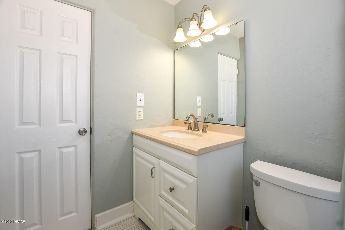 1509 Ridge Avenue Holly Hill, FL 32117 - Photo 20 of 40 a bathroom with a sink a toilet and a mirror