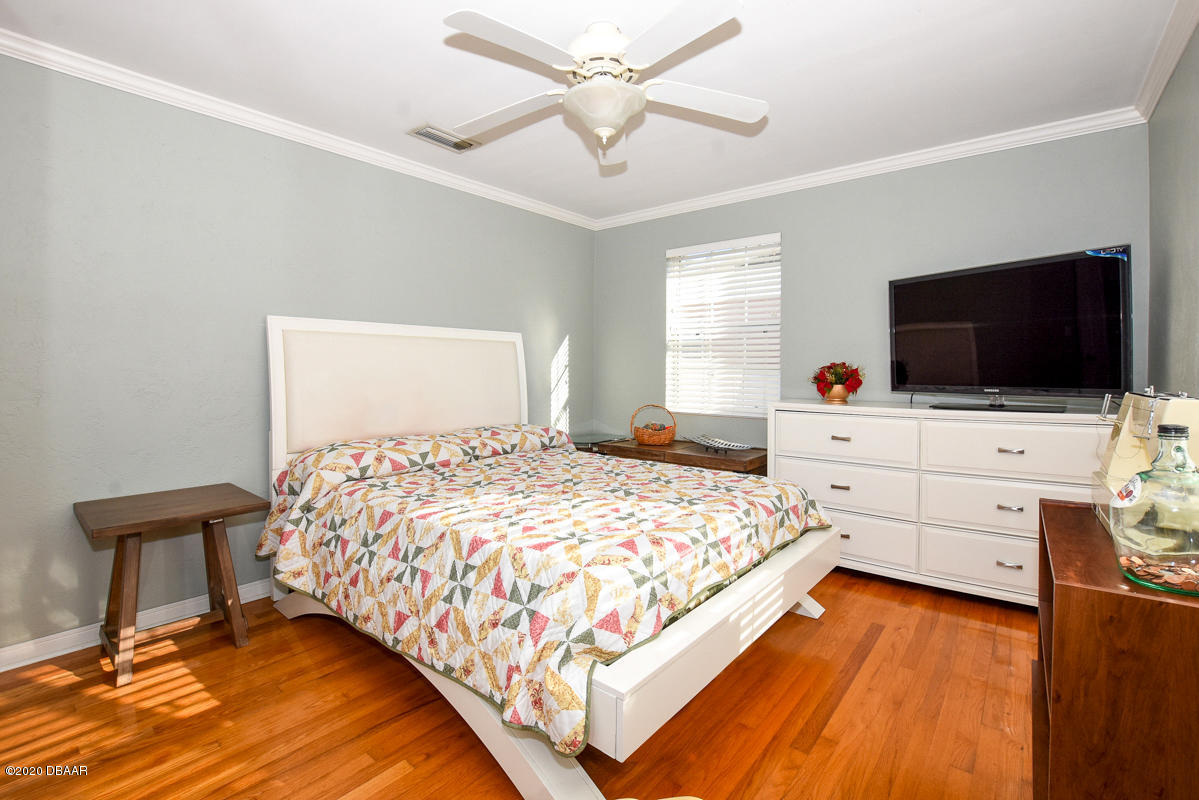 1509 Ridge Avenue Holly Hill, FL 32117 - Photo 22 of 40 a bedroom with a bed and flat tv screen on the dresser