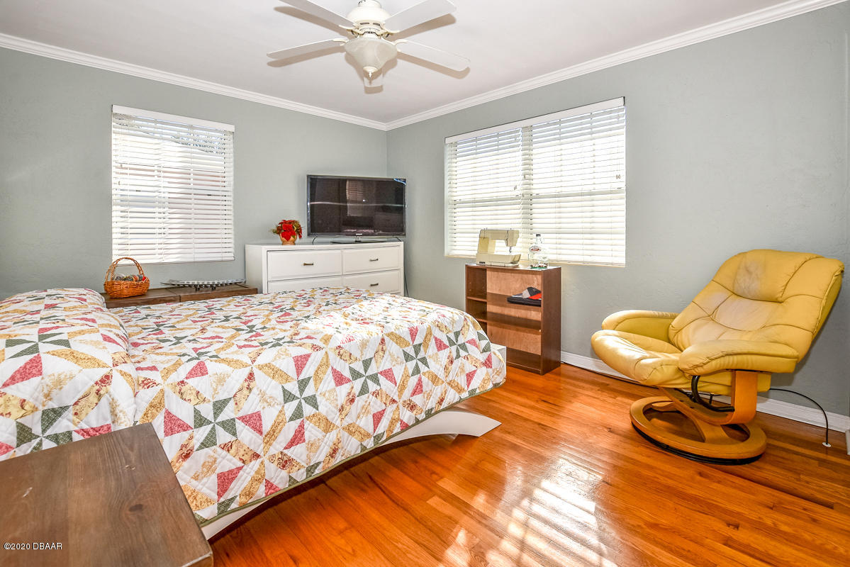 1509 Ridge Avenue Holly Hill, FL 32117 - Photo 24 of 40 a bedroom with a bed and a chair