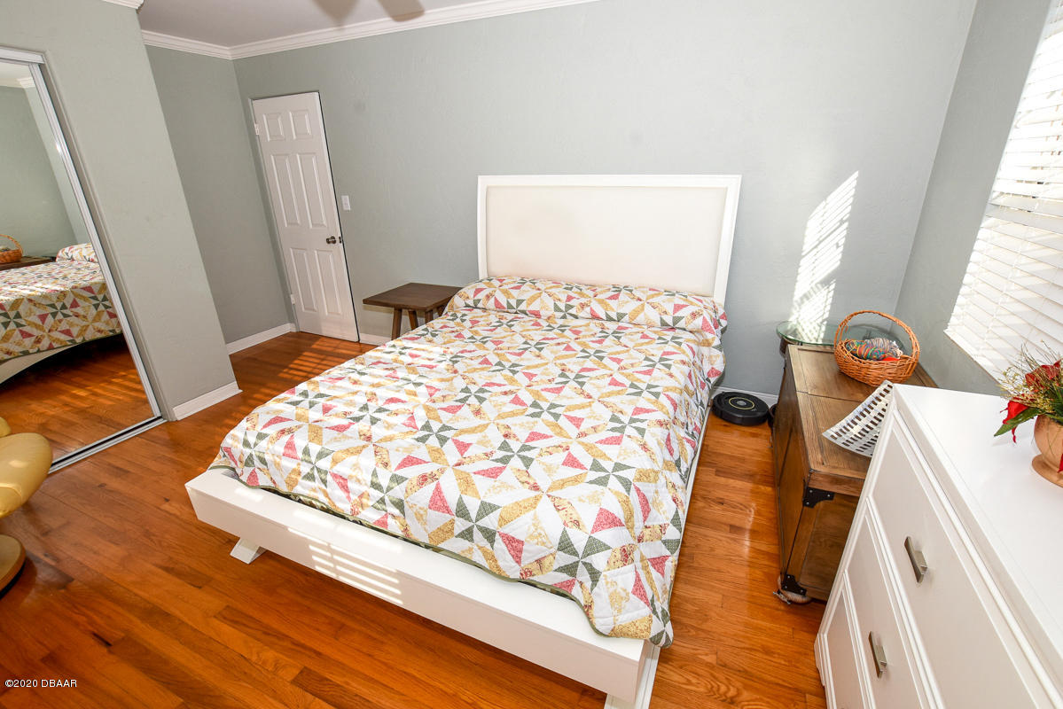 1509 Ridge Avenue Holly Hill, FL 32117 - Photo 25 of 40 a bedroom with a bed and wooden floor