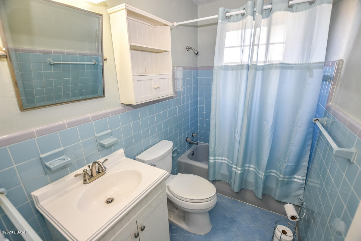 1509 Ridge Avenue Holly Hill, FL 32117 - Photo 26 of 40 a white toilet sitting next to a bathroom sink