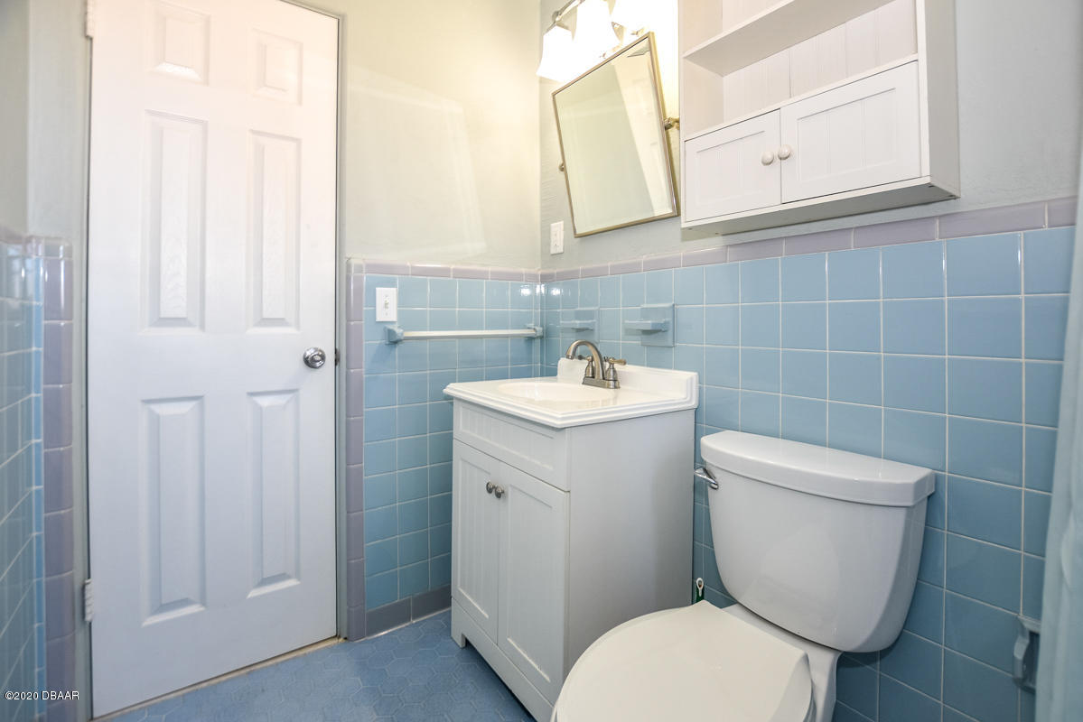 1509 Ridge Avenue Holly Hill, FL 32117 - Photo 27 of 40 a bathroom with a toilet sink and mirror