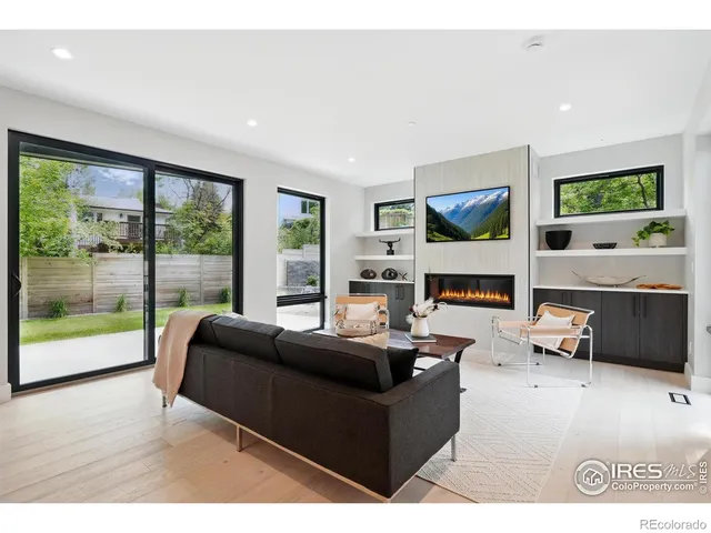 a living room with fireplace furniture and a large window