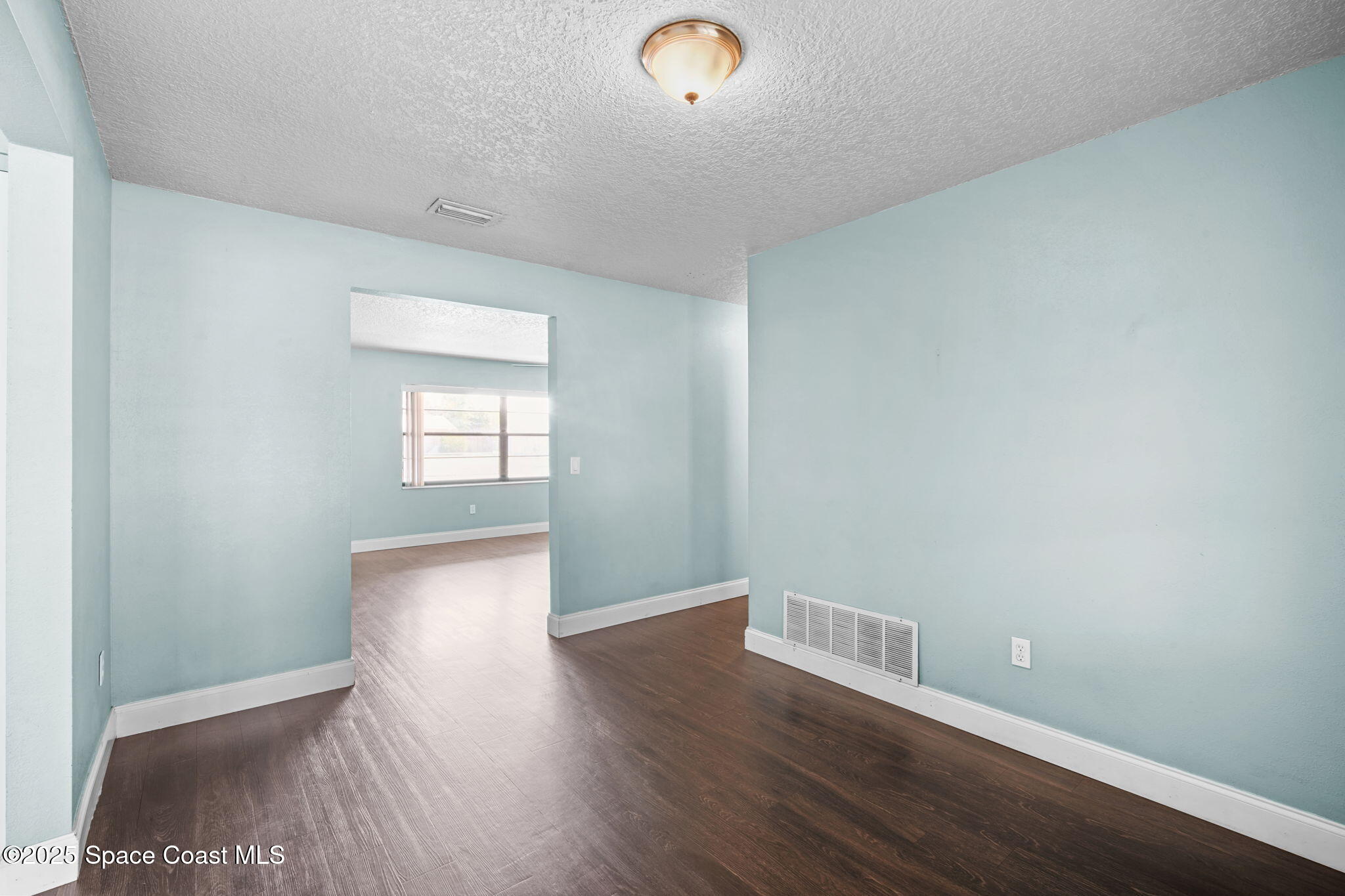 520 Croton Road Melbourne, FL 32935 - Photo 9 of 36 a view of an empty room with wooden floor and a window