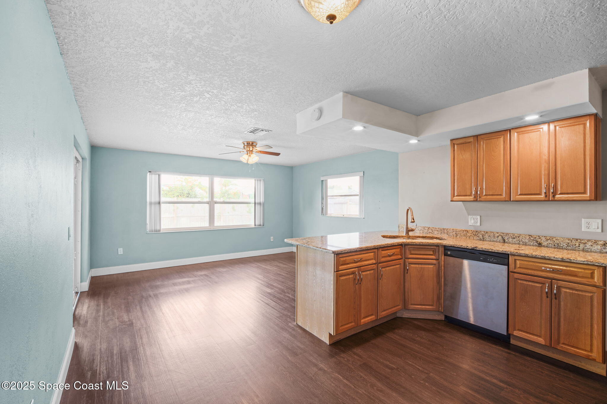 520 Croton Road Melbourne, FL 32935 - Photo 10 of 36 a kitchen with stainless steel appliances granite countertop wooden floors and sink