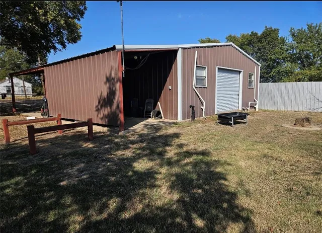 a view of backyard with wooden fence and a large tree