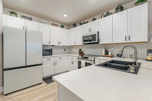 a kitchen with white cabinets and stainless steel appliances